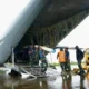 personel tni au menurunkan material tower emergency dari ruang kargo pesawat hercules di tengah kondisi hujan proses bongkar m 1764309442682 169